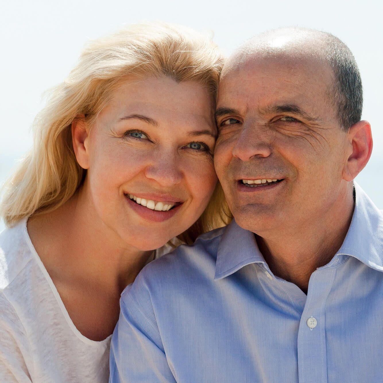 Mature woman and senior at sea beach on vacation smiling together