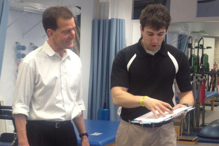 A therapist appears to be reviewing a treatment plan with a patient.