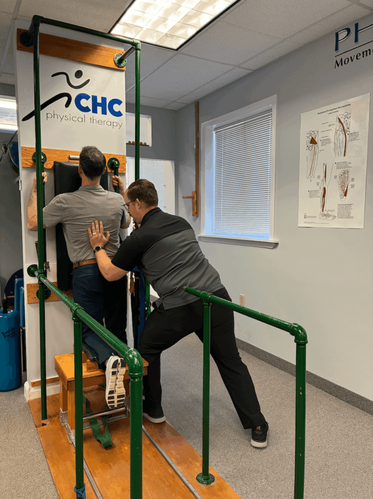 a physical therapist assisting a patient with a nerve mobilization exercise using specialized equipment, likely a Body Phyx machine.
