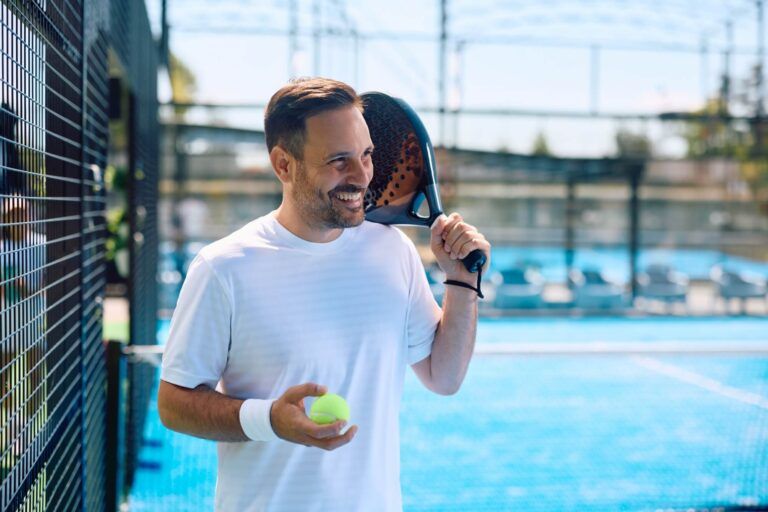 Portrait of happy paddle tennis player looking away