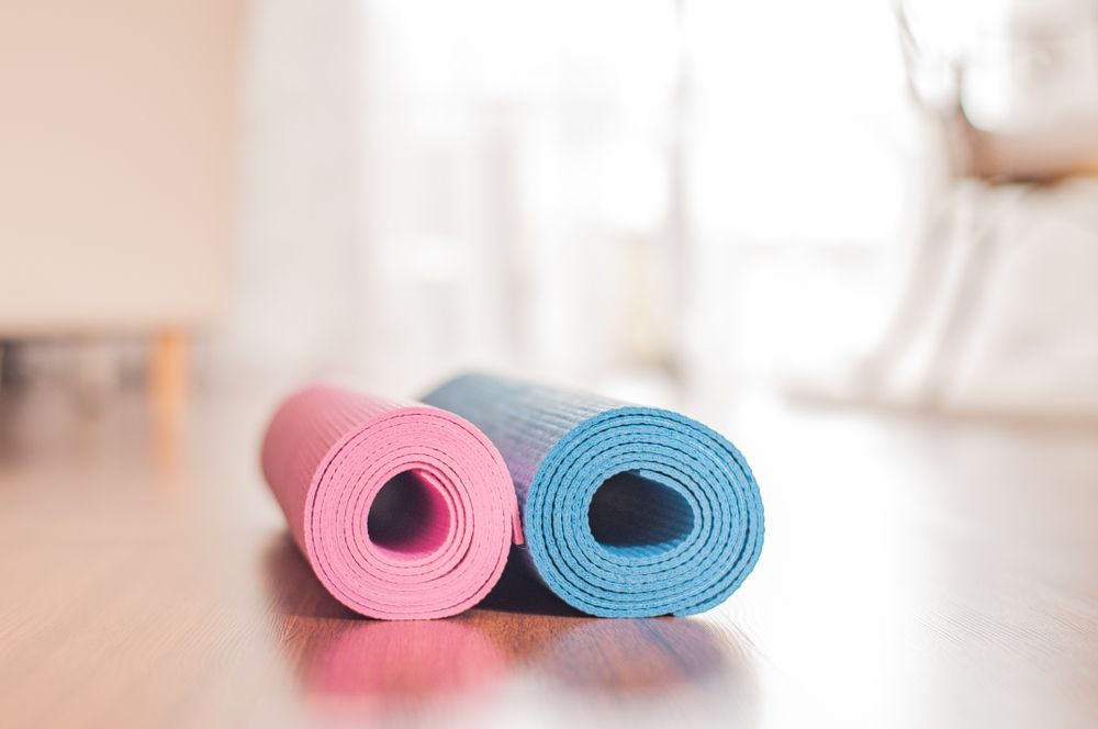 Yoga mats and dumbbells on wooden floor. Healthy lifestyle concept