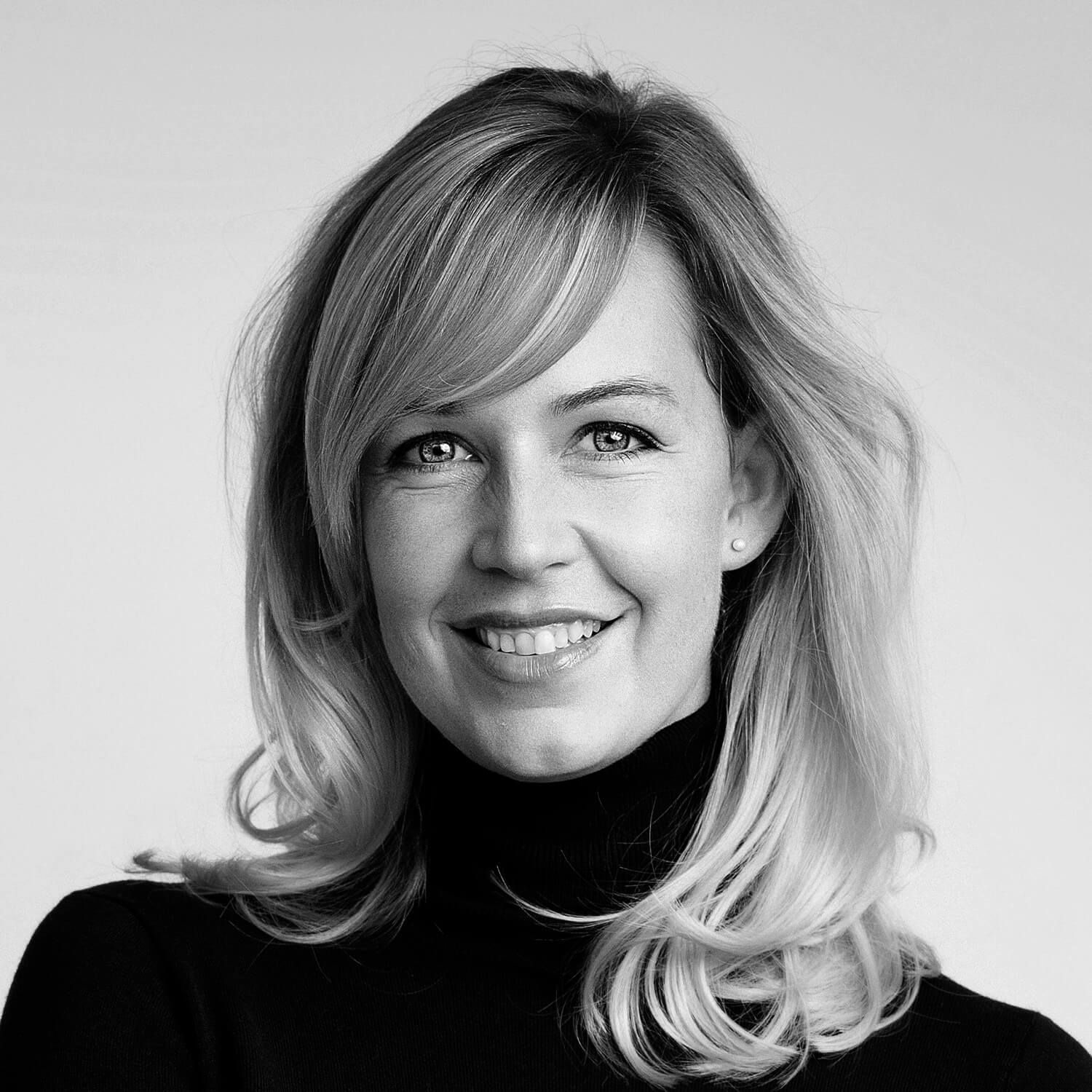 a portrait of a woman with blonde hair wearing a black turtleneck