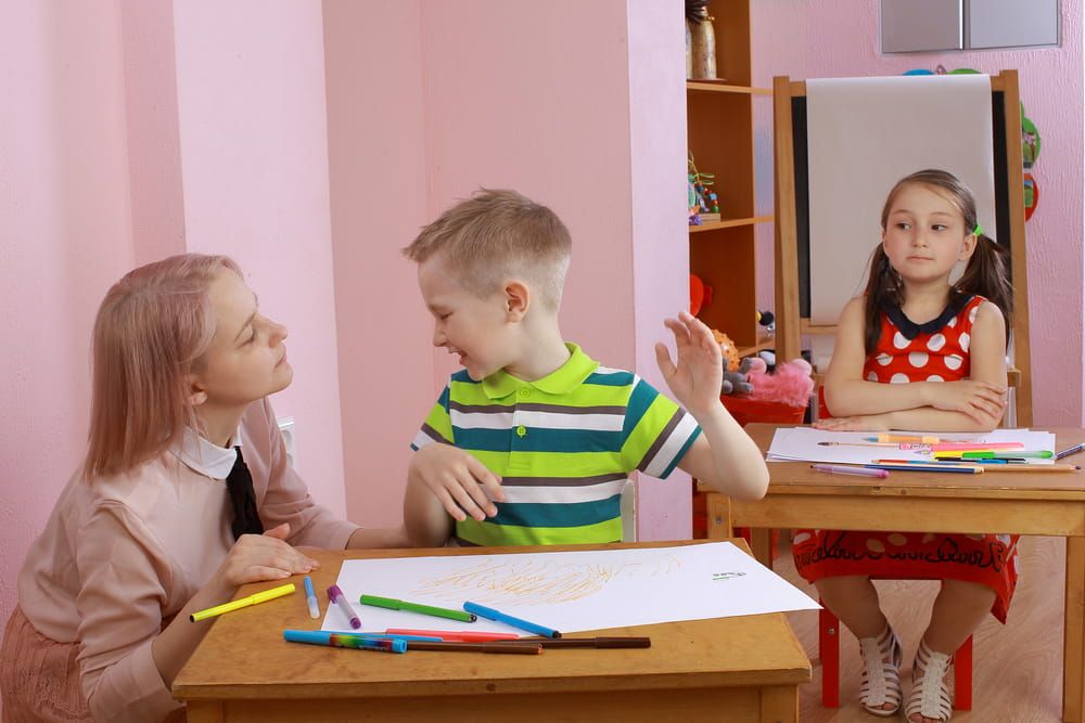the teacher in the class with a hyperactive child. hyperactive boy. the child indulges in the classroom. misbehaves. hyperactive boy