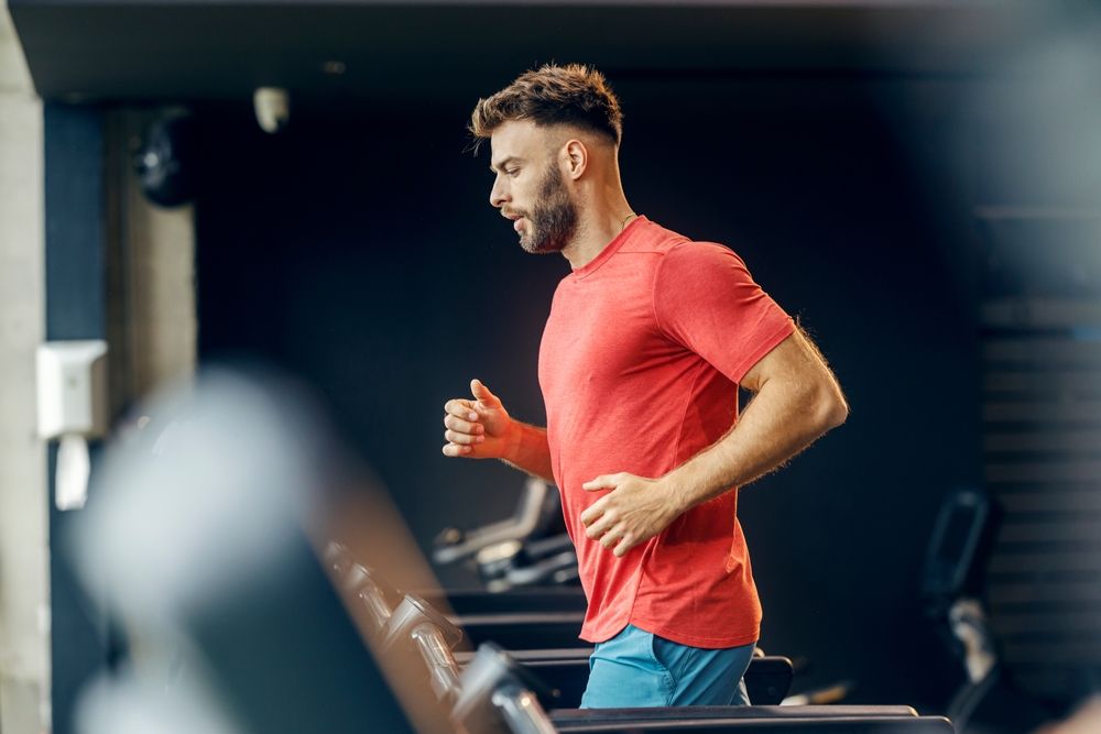fit man is running on treadmill
