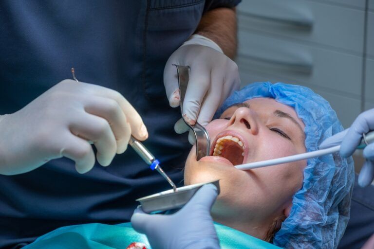 Dental professional works on patient mouth during application of bone graft material