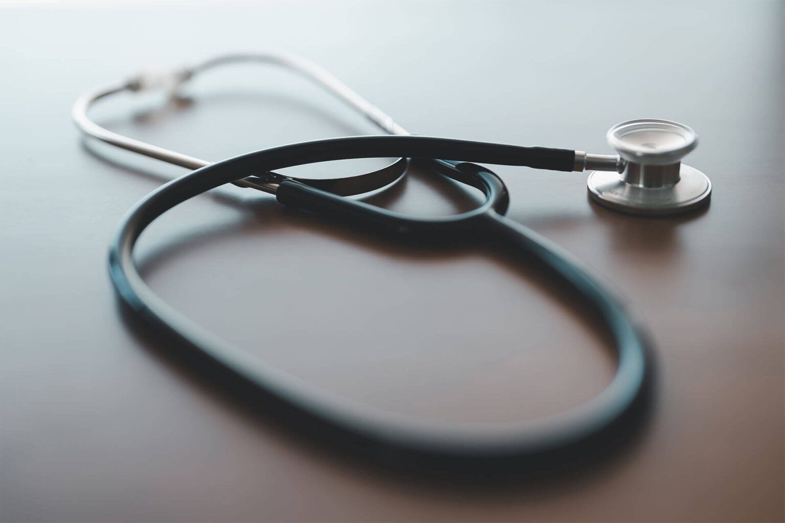 Black Stethoscope on Smooth Wooden Table
