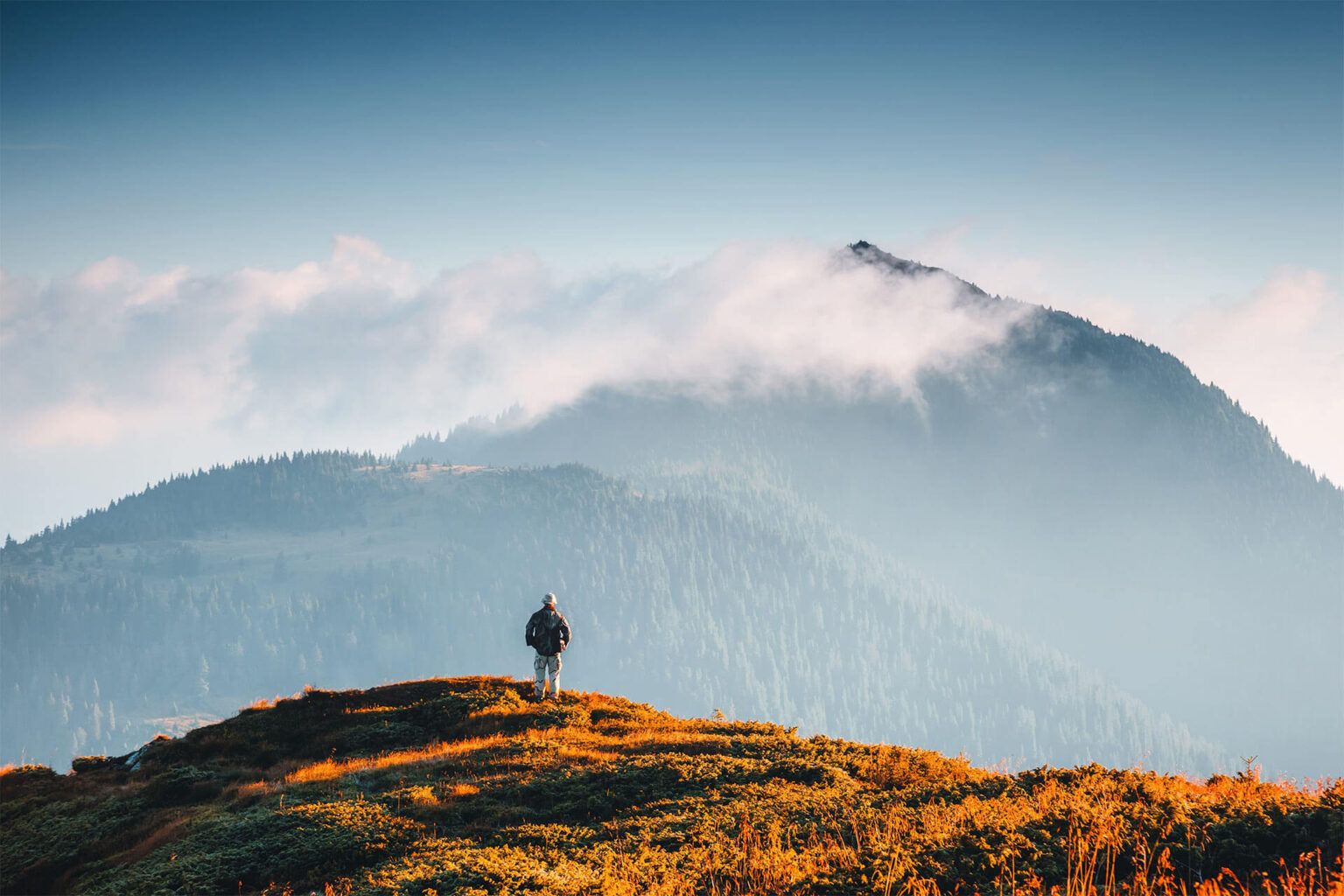 Stunning mountain landscape with a lone hiker exploring the beauty of nature under a clear sky