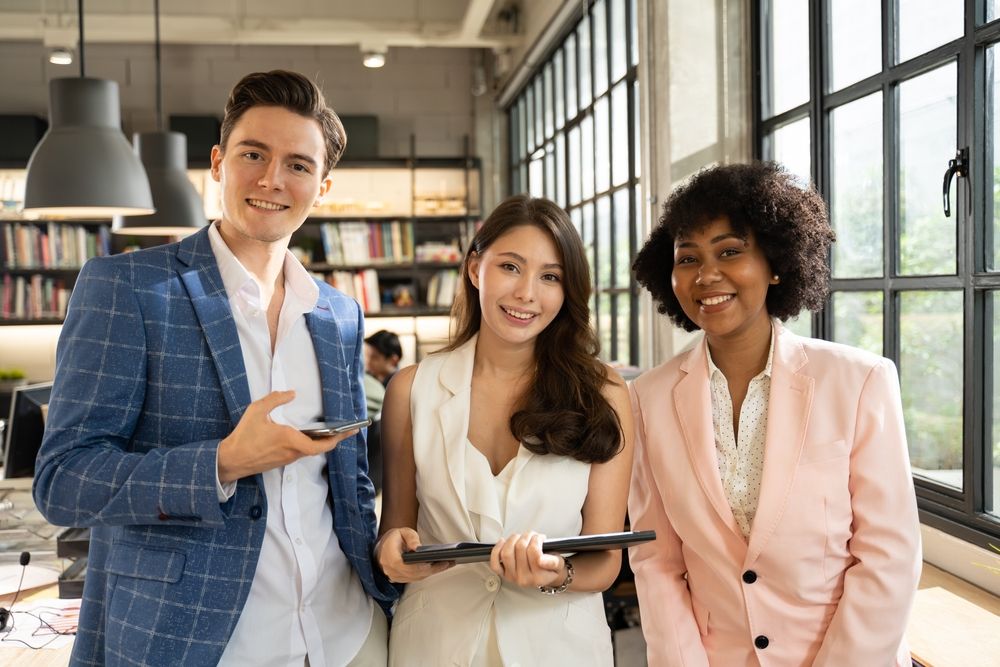 Successful company with happy workers concept.Group of happy creative business people and company staff standing together and smiling in modern office, representing company.