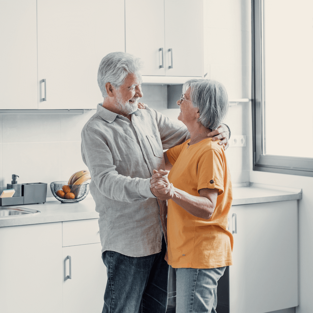 Joyful active old retired romantic couple dancing laughing