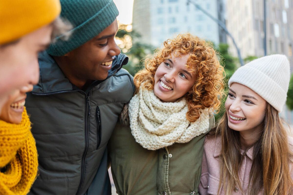 Young group of happy diverse friends having fun together on a cold day during winter vacation