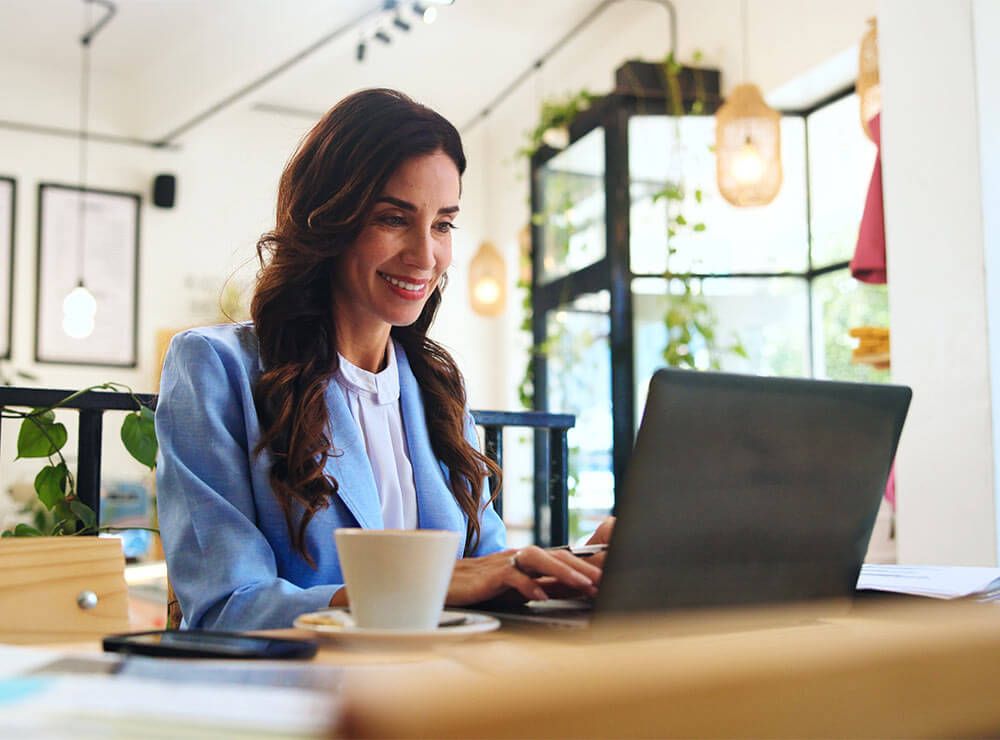 Happy, business and laptop with woman in cafe for typing, remote worker and research