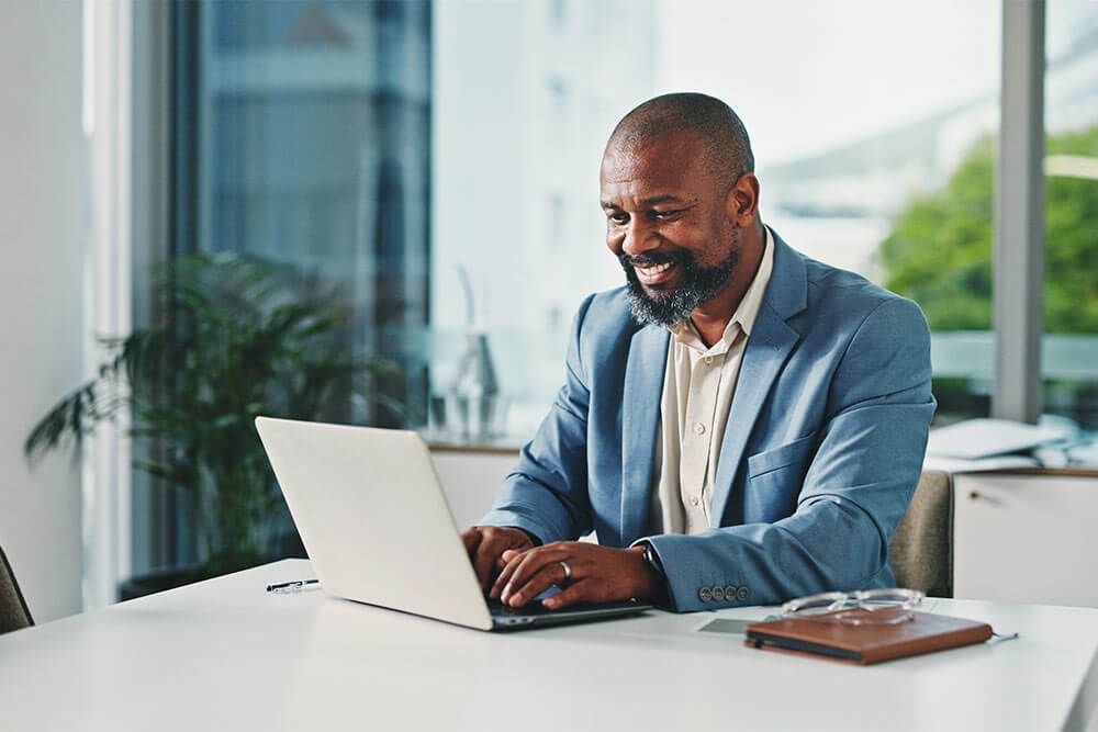 Laptop, happy and black man in office with research for finance report with business budget.