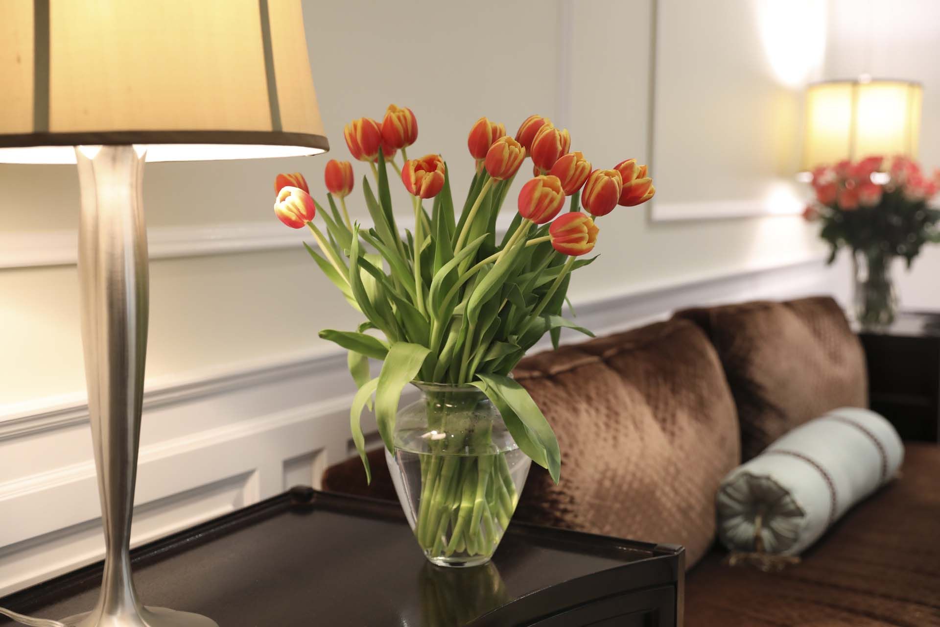 a bouquet of red and yellow tulips arranged in a clear glass vase, serving as home decor.