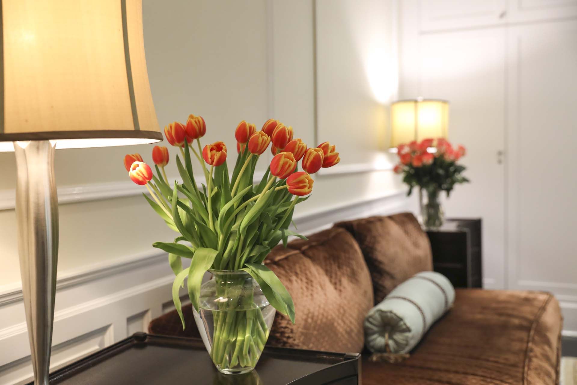 a bouquet of red and yellow tulips arranged in a clear glass vase, serving as home decor.