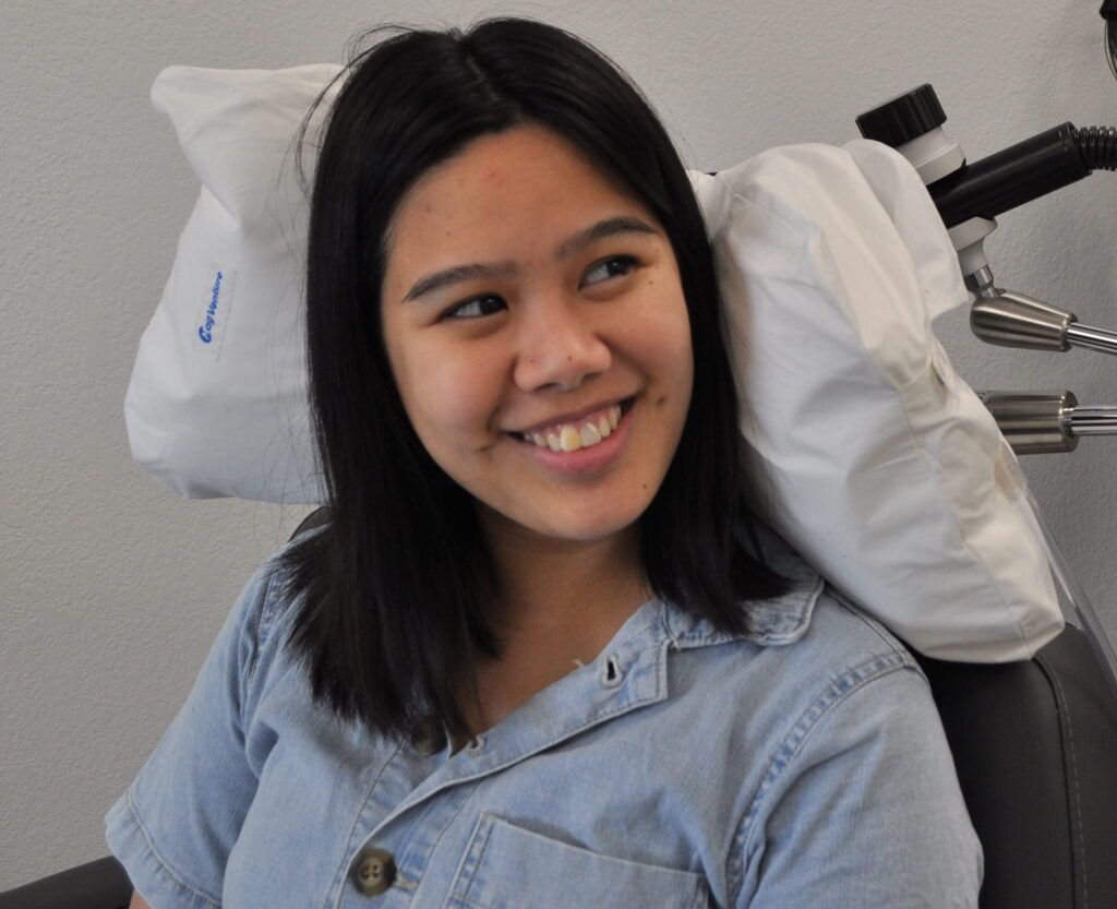 woman patient undergoing Precision Transcranial Magnetic Stimulation