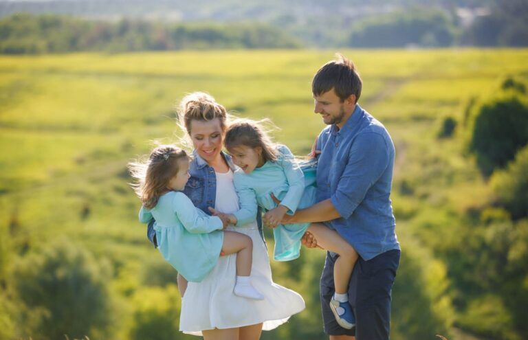 Happy young family mother and faHappy young family mother and father with two small children playing in the park.ther with two small children playing in the park.