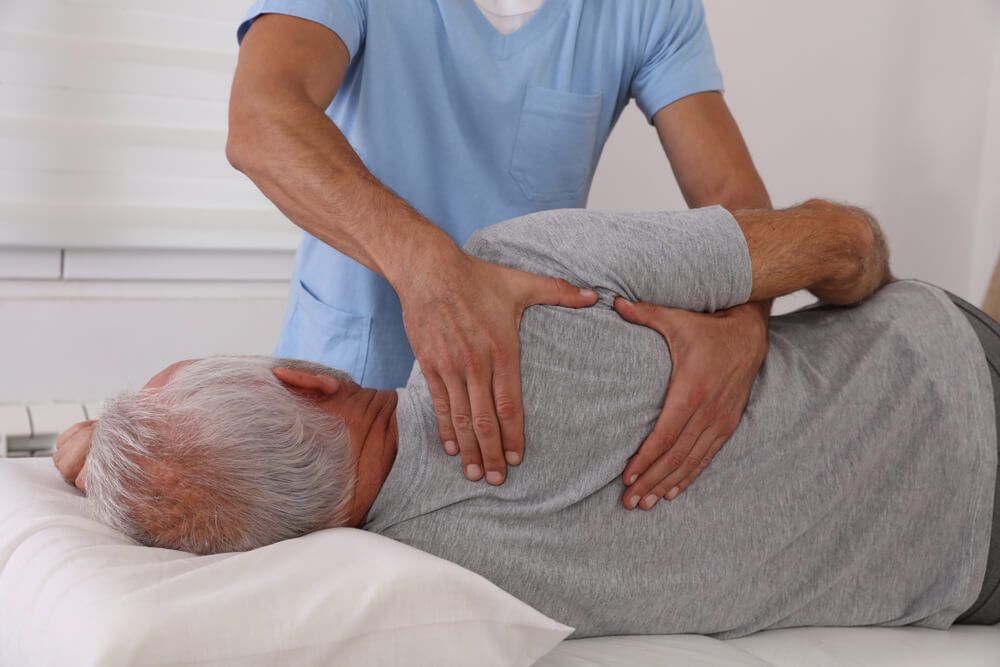 Chiropractic / Osteopathy treatment, Back pain relief. Physiotherapy for senior male patient, Kinesiology