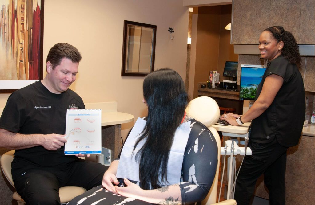 Dr. Ryan Anderson and staff consulting female patient