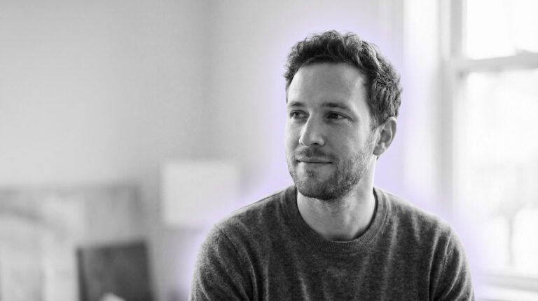 grayscale portrait of a guy in a calm reflective moment transitioning to a subtle sense of hope, soft natural light